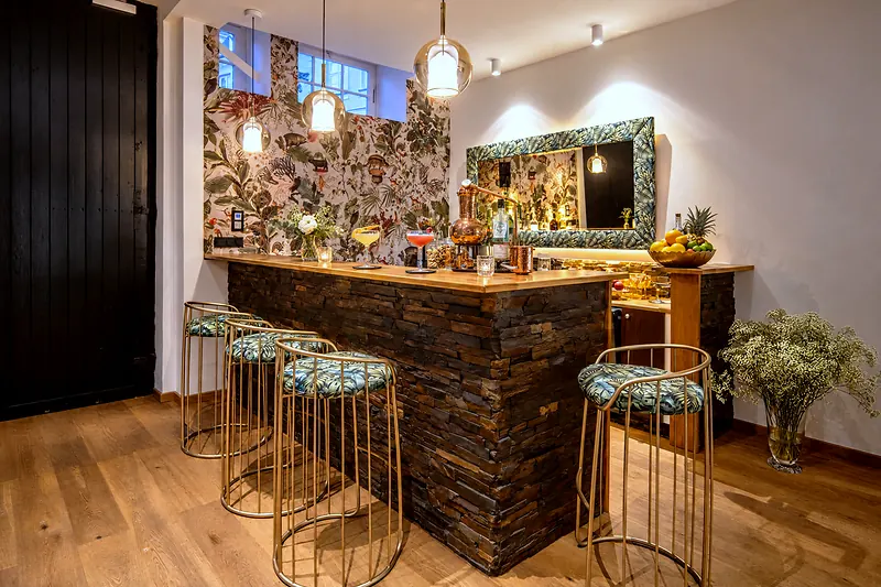 Die Bar in der Lounge mit Flaschenregal und Barhockern
