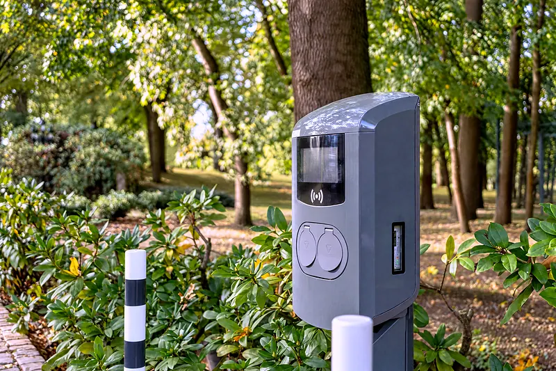 Die Ladesäule für Elektroautos zwischen den Bäumen