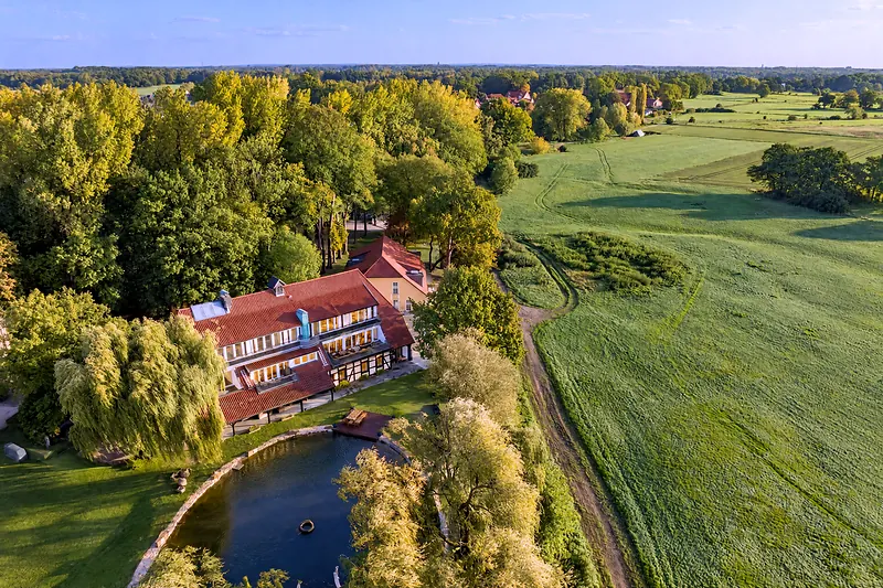Haus, Teich und Wiesen von oben