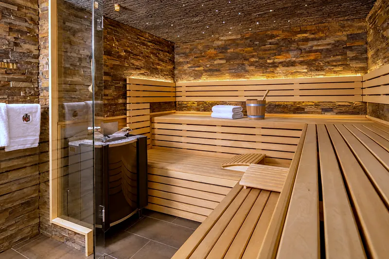 Die finnische Sauna mit Holzbänken hinter der Glastür
