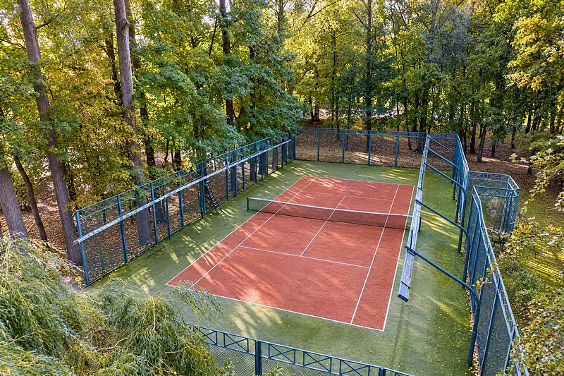 Der Tennisplatz zwischen den Bäumen des Parks