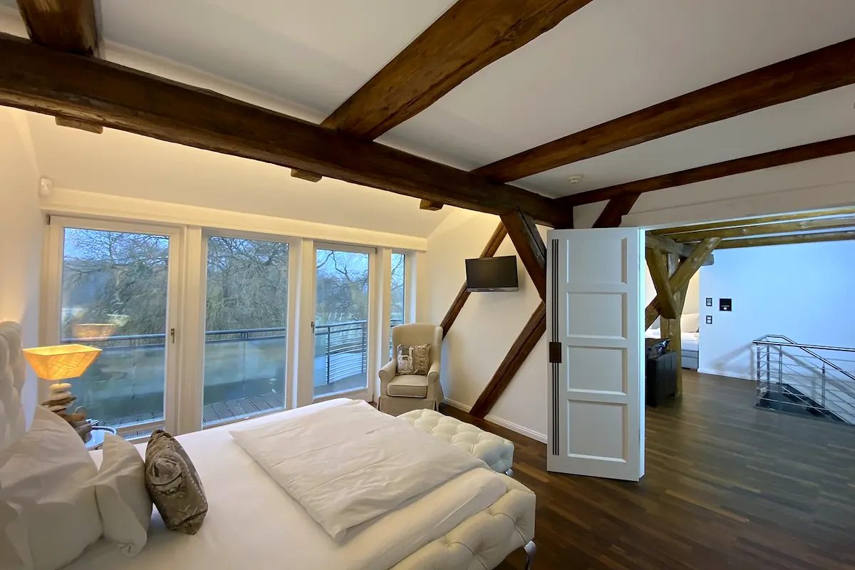 Slaapkamer van de suite Kronenkranich met openslaande deur en uitzicht op het groen